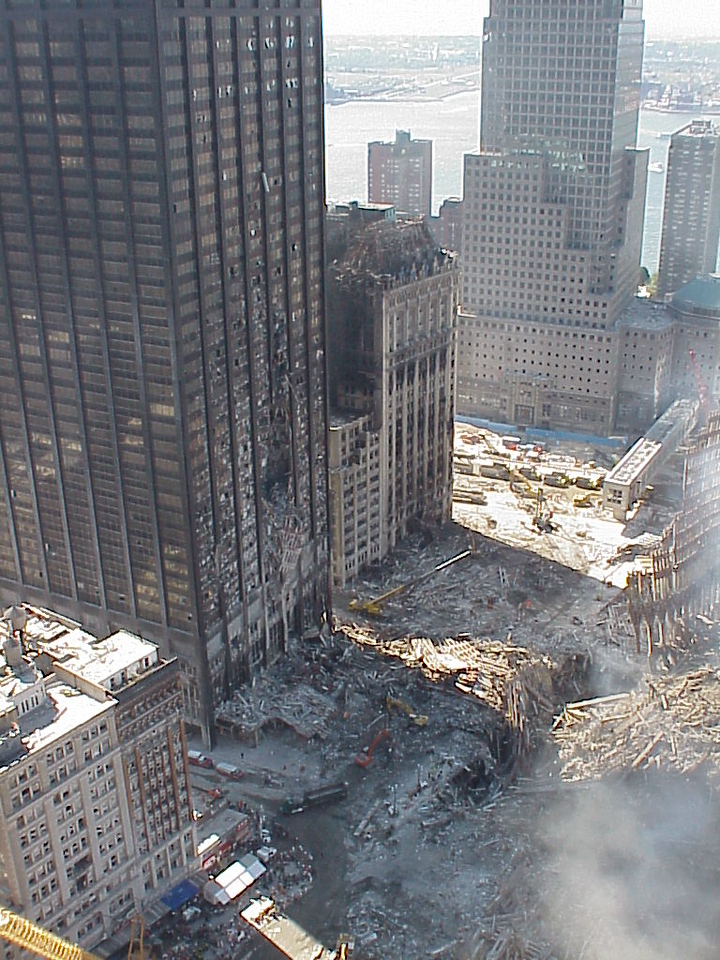 Steel beam showing missing lower portion while upper portion remains, contradicting top-down gravity damage pattern